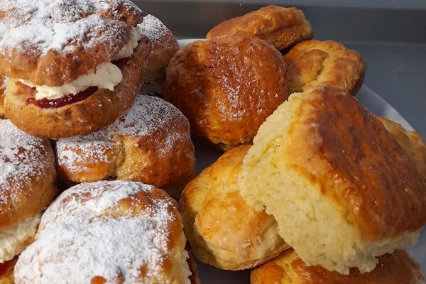 A plate of scones with cream and jam